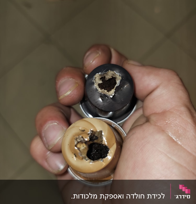קפסולות קפה עם חורים ביד אדם